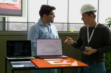 CAIDEL CEO Mostafa Hadadian in conversation with Olivér Kocsis from Engineering Trainer, in front of the Engineering Trainer booth showcasing the product search solution provided by CAIDEL.